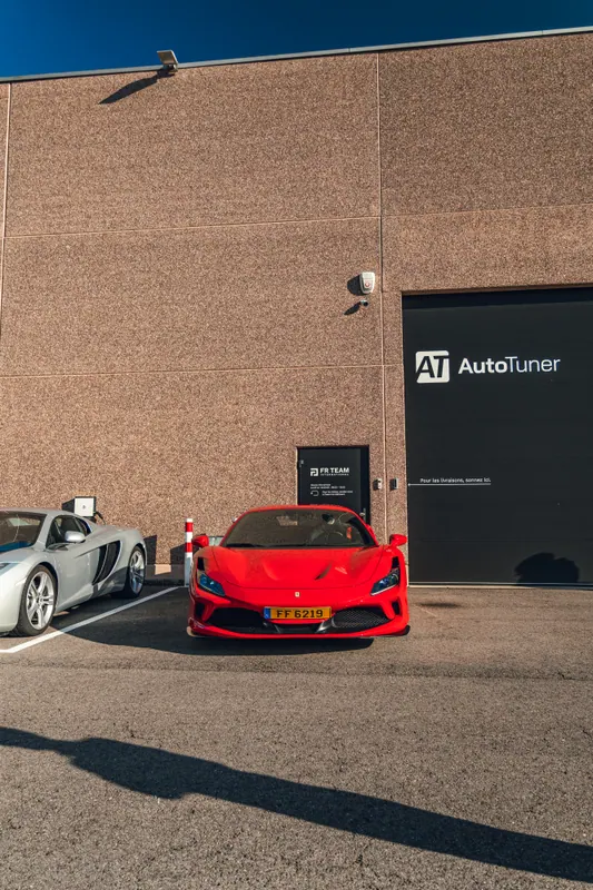 A red Ferrari parked with other cars