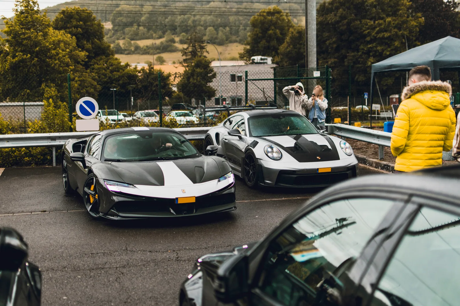 A grey Lamborghini and white Porsche in the event lineup