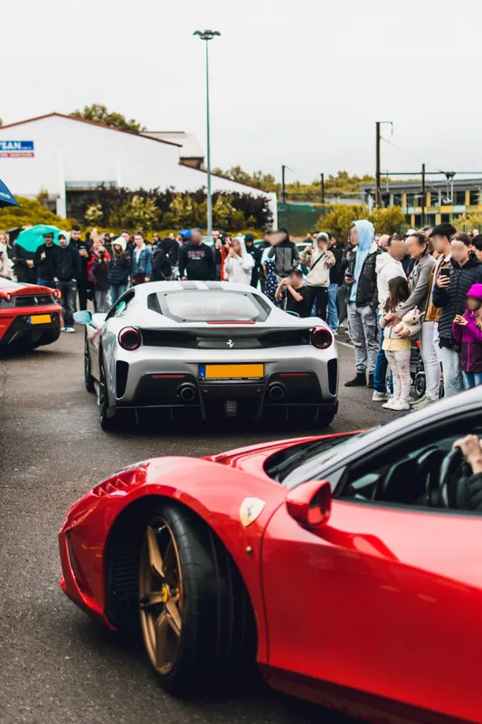 A row of sports cars with visitors